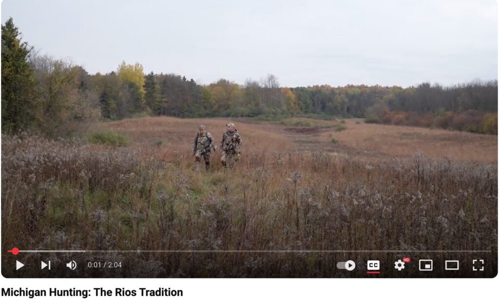 Still image from a YouTube video showing hunters walking through a field in autumn, titled "Michigan Hunting: The Rios Tradition."